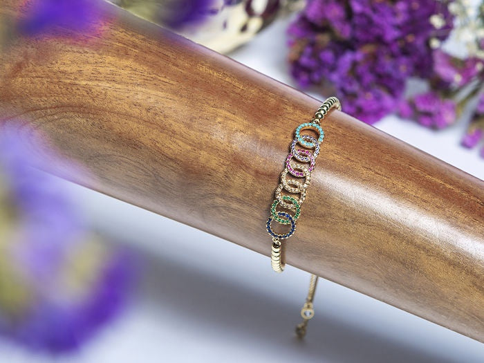 PULSO AJUSTABLE BOLITAS CON DIJE CIRCULOS ENTRELAZADOS ZIRCONIAS COLORES EN CHAPA DE ORO 14K
