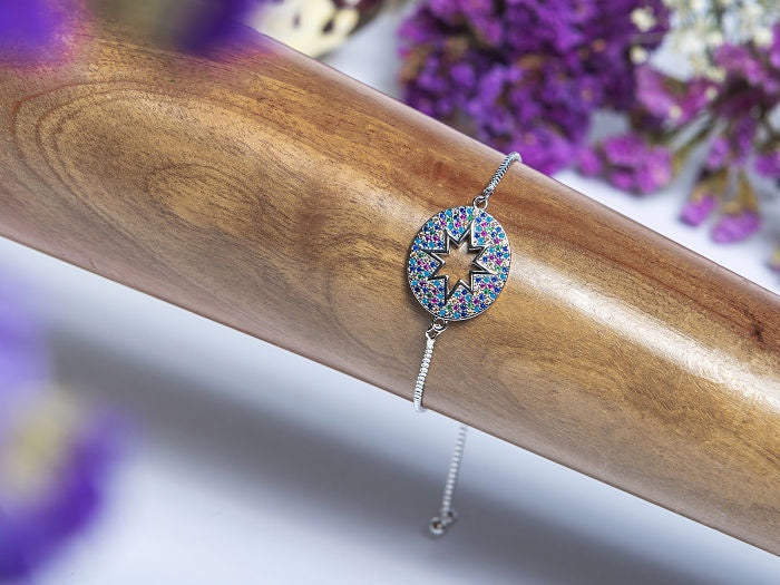 PULSO AJUSTABLE DIJE OVALADO ESTRELLA HUECA CON ZIRCONIAS DE COLORES, CON BAÑO DE RODIO
