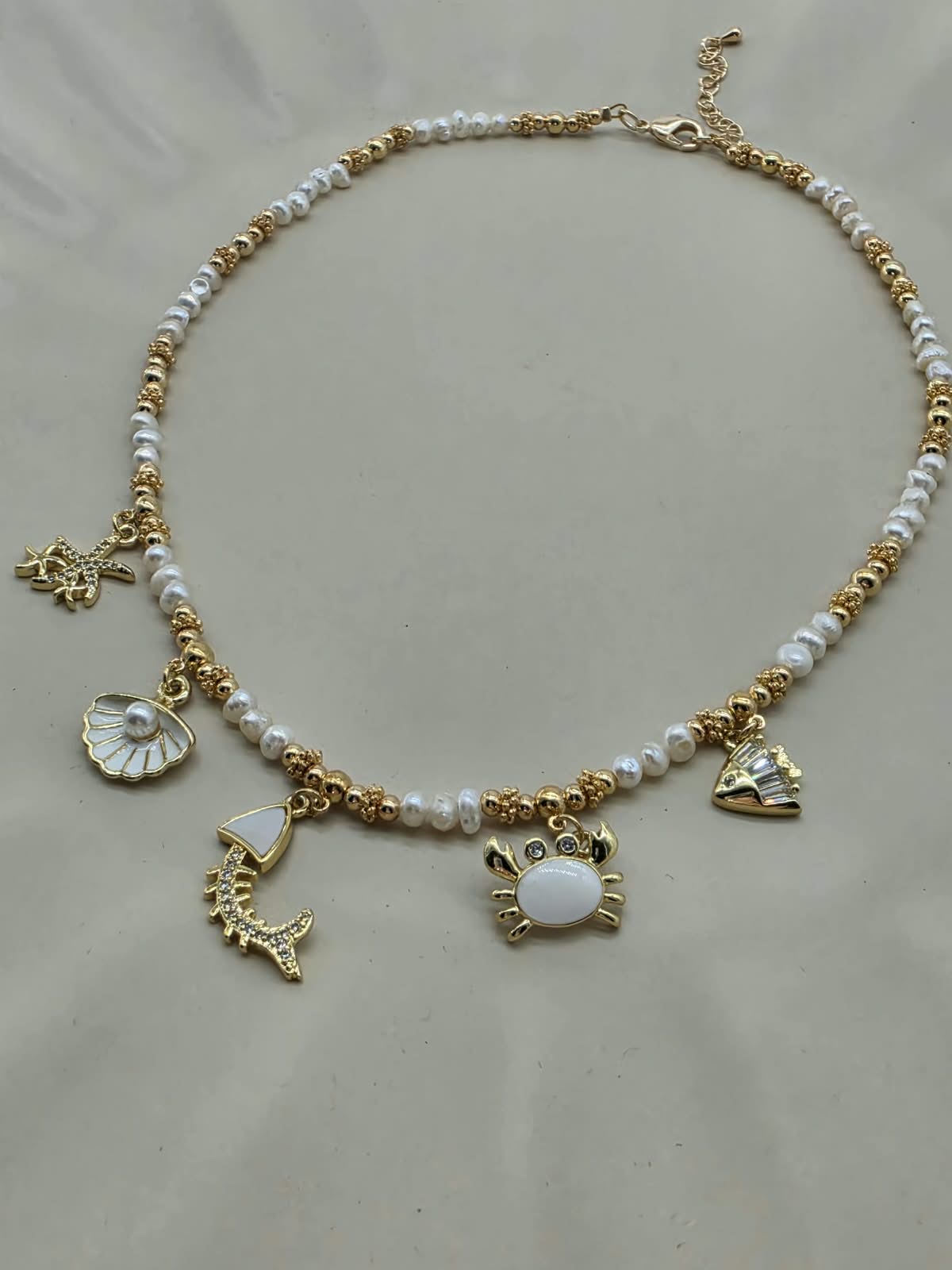 Collar multi dijes playa, con perlas naturales.