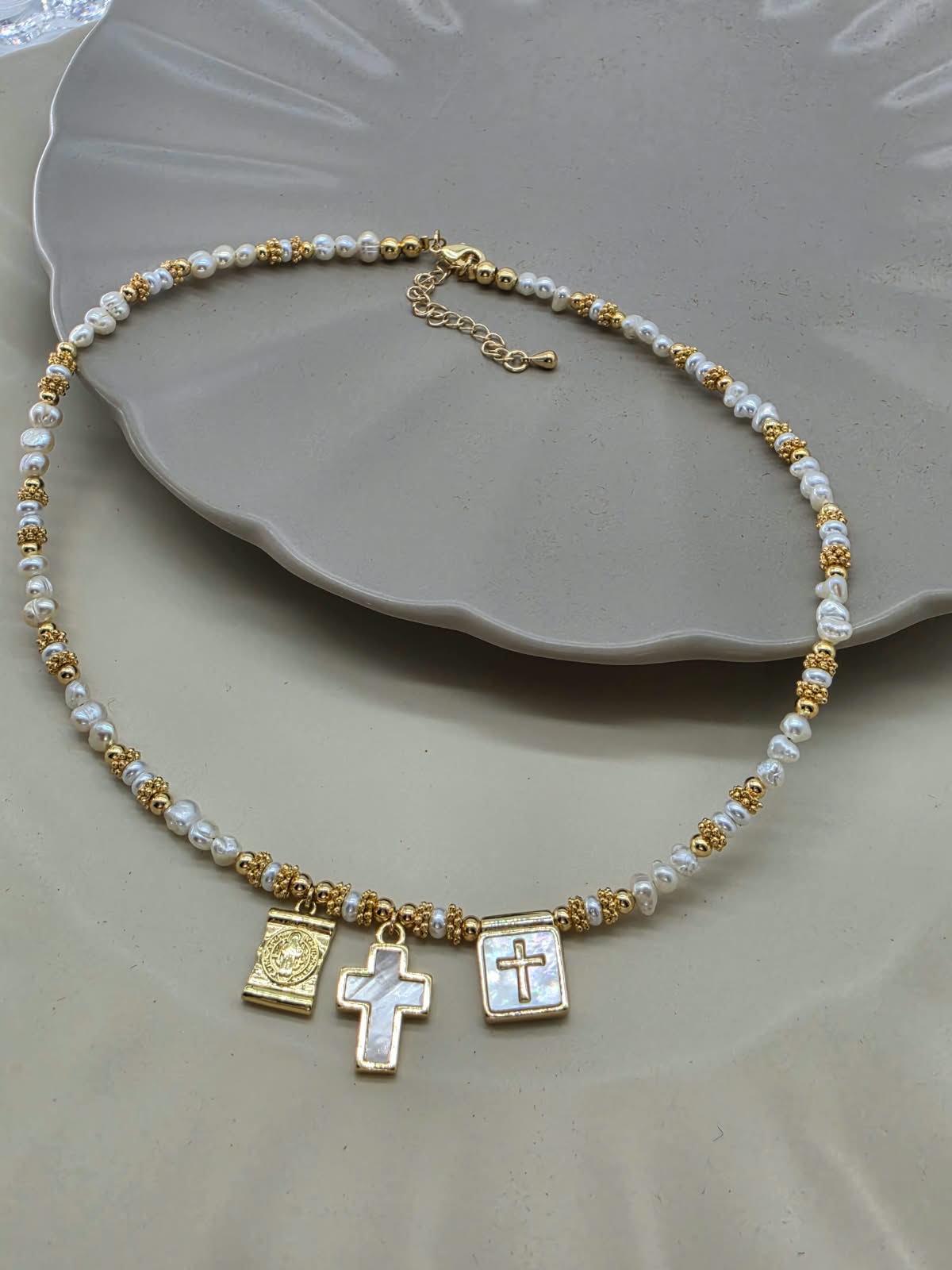 Collar dijes religiosos con madre perla.