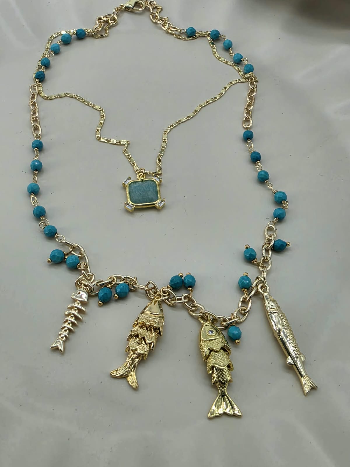 Collar doble azul, con multi dijes pez.